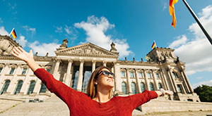An Overview of Living in Germany - An image of a cheerful woman outside of a large building near Bun
