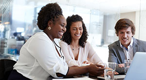 Work Etiquette in Germany - An image of two females and a male in an office, pleased with the outcom