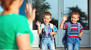 Moving to Germany with Children - An image of two young boys waving goodbye to their mother